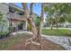 View of the townhome exterior featuring a patio, large tree, and stone walkway to the front door at 185 Scottsdale Sq # 185, Winter Park, FL 32792