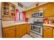 Bright kitchen featuring stainless steel appliances, tile countertops and light oak cabinets at 185 Scottsdale Sq # 185, Winter Park, FL 32792
