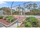 Community tennis court surrounded by fencing and greenery and stair access at 185 Scottsdale Sq # 185, Winter Park, FL 32792