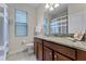 Well-lit bathroom with a vanity featuring granite countertop, blinds on the window and a shower with curtain at 2829 Autumn Breeze Way, Kissimmee, FL 34744