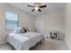 Neutral bedroom featuring a ceiling fan, window, and light carpet at 2829 Autumn Breeze Way, Kissimmee, FL 34744