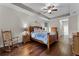 Bedroom featuring a ceiling fan, tray ceiling, and hardwood floors at 2829 Autumn Breeze Way, Kissimmee, FL 34744