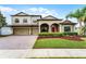 Charming two-story home with a well-manicured lawn, brick driveway, and an inviting red front door at 2829 Autumn Breeze Way, Kissimmee, FL 34744