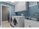Laundry room with modern washer and dryer, white cabinetry, and a sink for added convenience at 2829 Autumn Breeze Way, Kissimmee, FL 34744