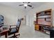 Bright office with a wooden desk, leather chair, and built in shelves for books and decor at 2829 Autumn Breeze Way, Kissimmee, FL 34744