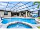 Screened pool area includes a waterfall spa, lounge seating, and a basketball hoop for recreation at 2829 Autumn Breeze Way, Kissimmee, FL 34744