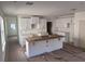 Unfinished kitchen with island, white cabinets, and stainless steel sink at 3171 Cup Dr, Lakeland, FL 33803