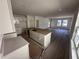 Open concept kitchen with white cabinets and a large island connecting to living room at 3171 Cup Dr, Lakeland, FL 33803