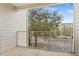 Balcony with a metal railing overlooking mature trees and a parking lot on a clear, sunny day at 3176 Feltrim Pl # 205, Kissimmee, FL 34747