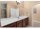 Well lit bathroom with a single sink, dark wood cabinets, large mirror, and a glass shower door at 3176 Feltrim Pl # 205, Kissimmee, FL 34747