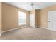 A simple bedroom with neutral colored walls and carpet, a ceiling fan, and a window with blinds at 3176 Feltrim Pl # 205, Kissimmee, FL 34747