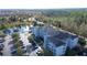 Aerial view of a multi-story apartment building nestled among lush greenery and overlooking a tranquil pond at 3176 Feltrim Pl # 205, Kissimmee, FL 34747