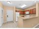Bright kitchen featuring wood cabinetry, white appliances, and a convenient breakfast bar, perfect for casual dining at 3176 Feltrim Pl # 205, Kissimmee, FL 34747