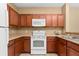 Functional kitchen with wood cabinets, white appliances, and ample counter space for meal preparation at 3176 Feltrim Pl # 205, Kissimmee, FL 34747