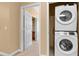 A laundry area featuring a stacked Samsung washer and dryer with a doorway visible to another room at 3176 Feltrim Pl # 205, Kissimmee, FL 34747