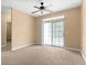 Well-lit living room with neutral carpet and sliding glass door to the balcony at 3176 Feltrim Pl # 205, Kissimmee, FL 34747