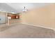 Spacious living room with neutral carpet, a chandelier, and an open view to the kitchen and dining area at 3176 Feltrim Pl # 205, Kissimmee, FL 34747