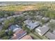 A scenic aerial view of a residential community surrounded by lush trees, featuring various housing styles and a distant wetland area at 325 Bellingrath Terrace, Deland, FL 32724