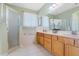 Bathroom with dual sinks, wood cabinets, tile floors, a glass enclosed shower and tub at 325 Bellingrath Terrace, Deland, FL 32724
