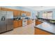 Bright kitchen features stainless steel appliances, wood cabinets, tile flooring and stone countertops at 325 Bellingrath Terrace, Deland, FL 32724