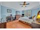 Comfortable bedroom featuring light blue walls, wood flooring, and a ceiling fan with light at 466 Ashley Brooke Ct # C, Apopka, FL 32712
