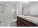Bright bathroom featuring a glass-enclosed shower, vanity with dark wood cabinets, and a large mirror at 4897 Gilded Jewel Dr, Mount Dora, FL 32757