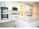 Bright kitchen features white cabinets, stainless steel appliances, gas cooktop, and an island with granite countertops at 4897 Gilded Jewel Dr, Mount Dora, FL 32757