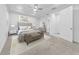 Bright main bedroom with tray ceiling, ceiling fan, neutral decor, and ensuite access at 4897 Gilded Jewel Dr, Mount Dora, FL 32757