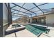 Beautiful screened-in pool with a hot tub, surrounded by a spacious patio, offering a perfect outdoor living space at 4897 Gilded Jewel Dr, Mount Dora, FL 32757