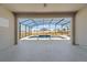 Stunning view from covered patio to sparkling screened-in pool and spa, set against a backdrop of a beautifully landscaped yard at 4897 Gilded Jewel Dr, Mount Dora, FL 32757