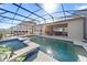 Inviting screened-in pool with a spa, surrounded by lush greenery and outdoor seating, creating a relaxing oasis at 4897 Gilded Jewel Dr, Mount Dora, FL 32757