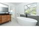 Bathroom featuring a soaking tub near the window and vanity with wooden cabinets at 5136 Stratemeyer Dr, Orlando, FL 32839