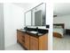 Bathroom with dual vanity with wooden cabinets and black countertop at 5136 Stratemeyer Dr, Orlando, FL 32839