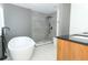Bathroom featuring a soaking tub, a walk-in shower, and a vanity with wooden cabinets at 5136 Stratemeyer Dr, Orlando, FL 32839
