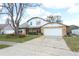 Charming two-story home with a brick facade, large tree, and a two-car garage at 5136 Stratemeyer Dr, Orlando, FL 32839