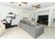 Open-concept living room with plenty of natural light, gray sofa, and access to multiple rooms at 5136 Stratemeyer Dr, Orlando, FL 32839