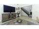 Cozy living room featuring a large entertainment center, stylish decor, and staircase at 5136 Stratemeyer Dr, Orlando, FL 32839