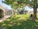 Expansive backyard featuring a screened lanai, mature trees, and lush lawn, perfect for outdoor living at 777 Crepe Myrtle Cir, Apopka, FL 32712