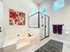 Bathroom featuring a soaking tub, a glass enclosed shower, and decorative painting at 777 Crepe Myrtle Cir, Apopka, FL 32712