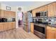 Bright kitchen with stainless steel appliances, tile backsplash, and wood-look flooring at 777 Crepe Myrtle Cir, Apopka, FL 32712