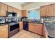 Kitchen featuring wooden cabinetry, granite countertops, stainless steel appliances, and backsplash tiles at 777 Crepe Myrtle Cir, Apopka, FL 32712