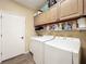Well-organized laundry room with washer, dryer, utility sink and storage shelves at 777 Crepe Myrtle Cir, Apopka, FL 32712