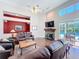 Living area with hardwood floors, stone fireplace, and a sliding glass door to the outdoor living area at 777 Crepe Myrtle Cir, Apopka, FL 32712