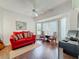 Cozy living room with a red sofa, two chairs, and a work desk near a bay window at 777 Crepe Myrtle Cir, Apopka, FL 32712