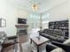 Open living room featuring a stone fireplace, leather furniture, and backyard views at 777 Crepe Myrtle Cir, Apopka, FL 32712