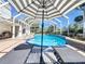 Shaded lounge chairs next to the pool in screened enclosure with umbrella table at 777 Crepe Myrtle Cir, Apopka, FL 32712