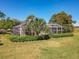 Large screened lanai surrounded by manicured hedges offers privacy and insect-free outdoor living at 777 Crepe Myrtle Cir, Apopka, FL 32712