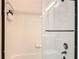 Shower featuring white tiled walls, glass door, and black hardware at 777 Crepe Myrtle Cir, Apopka, FL 32712