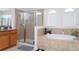Elegant bathroom featuring a walk-in shower, soaking tub and neutral tile at 8231 Chilton Dr, Orlando, FL 32836