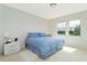 Well-lit bedroom with two windows, neutral color carpet, a nightstand and a queen bed at 8231 Chilton Dr, Orlando, FL 32836